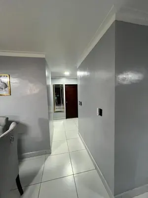 a hallway with white walls and white tile floors at Apartamento amueblado in Arenoso