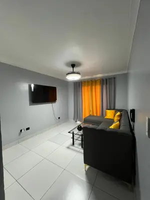 a living room with a couch and a flat screen tv at Apartamento amueblado in Arenoso