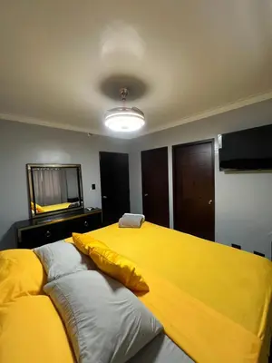 a bedroom with a large bed with a yellow blanket at Apartamento amueblado in Arenoso