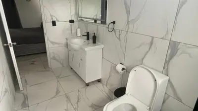 a bathroom with a toilet and a sink and a mirror at Level Suites 3 Premium Suite in Sosúa