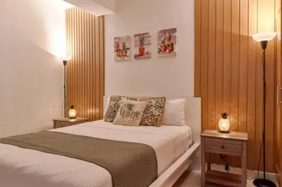 a bedroom with a bed with two night stands and two lamps at Gorgeous Banana Places QDA-IV in Santo Domingo