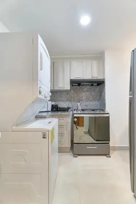 a kitchen with white cabinets and stainless steel appliances at Gorgeous Banana Places QDA-IV in Santo Domingo