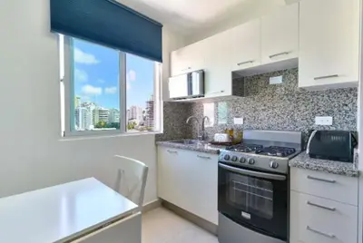 a kitchen with white cabinets and a stove top oven at Gorgeous Banana Places QDA-IV in Santo Domingo