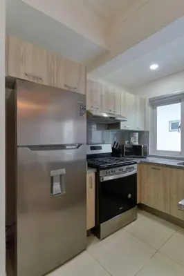 a kitchen with a stainless steel refrigerator and a stove at Natural Boho Places QDA-III in Santo Domingo