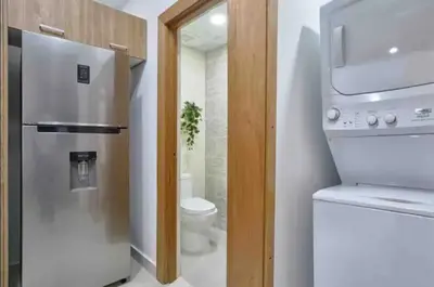 a small kitchen with a refrigerator and a toilet at Natural Boho Places QDA-III in Santo Domingo