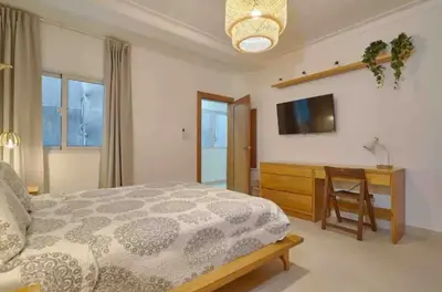 a bedroom with a bed and a television and a table at Natural Boho Places QDA-III in Santo Domingo