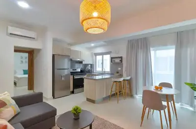 a living room and kitchen with a couch and a table at Natural Boho Places QDA-III in Santo Domingo