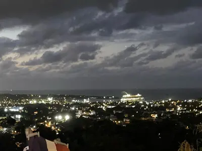 a view of a city at night with a cruise ship at Cozy Apt with Puerto Plata view in San Felipe de Puerto Plata