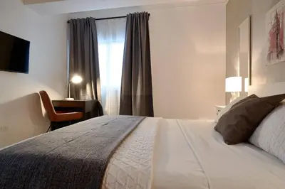 a bedroom with a bed and a desk and a window at Luxury and Cozy Places QDA-II in Santo Domingo