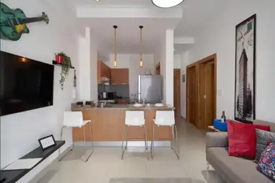 a living room with a couch and a kitchen at Luxury and Cozy Places QDA-II in Santo Domingo