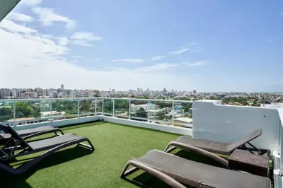 a balcony with chairs and grass on a building at Luxury and Cozy Places QDA-II in Santo Domingo