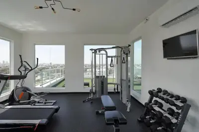 a gym with cardio machines and a flat screen tv at Luxury and Cozy Places QDA-II in Santo Domingo