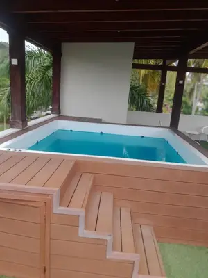 a pool in a house with a wooden deck and a swimming pool at Vacacional Laas Pascualas in Sánchez
