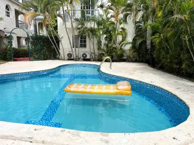 a swimming pool with a raft in the middle at Cozy Condo - 4 min to the Beach in Punta Cana