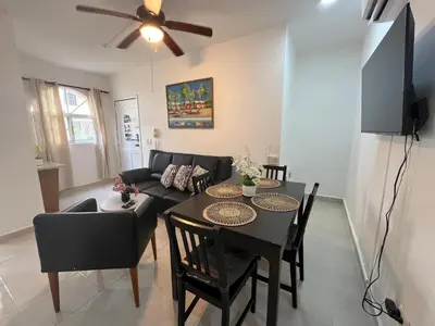 a living room with a table and a couch at Cozy Condo - 4 min to the Beach in Punta Cana
