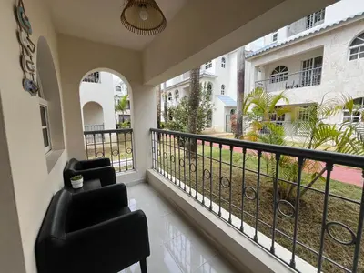 a balcony with a chair and a view of a yard at Cozy Condo - 4 min to the Beach in Punta Cana