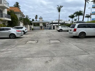 a parking lot with several cars parked in it at Cozy Condo - 4 min to the Beach in Punta Cana