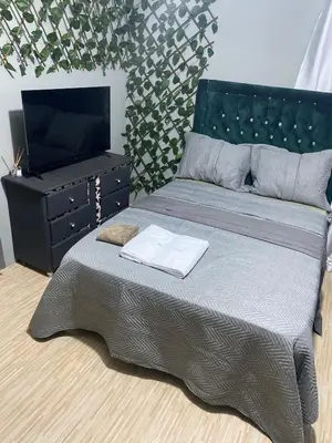 a bedroom with a bed and a dresser and a television at Habitación a 15min del aeropuerto in La Caleta