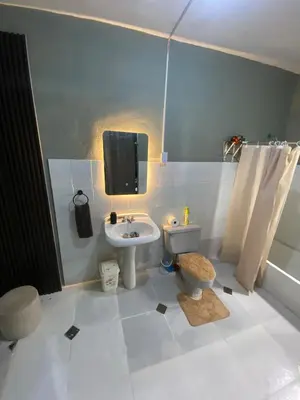 a bathroom with a sink and a toilet and a tv at Habitación a 15min del aeropuerto in La Caleta