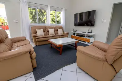 a living room with two couches and a tv at Villa Olga in Sosúa