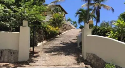 a dirt road leading to a house with palm trees at Villa with Stunning Ocean View, Infinity pool in Las Terrenas