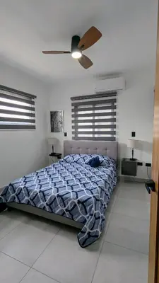 a bedroom with a bed and a ceiling fan at Mountain View Penthouse Condo in Muñoz