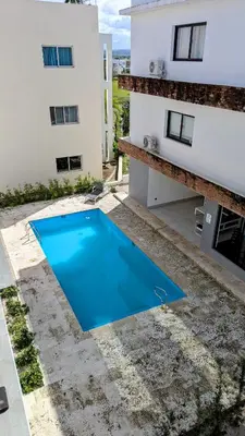 a blue swimming pool in front of a building at Mountain View Penthouse Condo in Muñoz