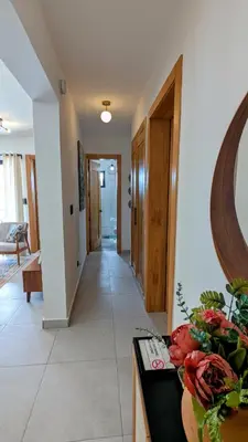 a hallway of a house with a table with flowers at Mountain View Penthouse Condo in Muñoz