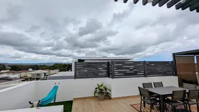 a balcony with a table and chairs on a building at Mountain View Penthouse Condo in Muñoz