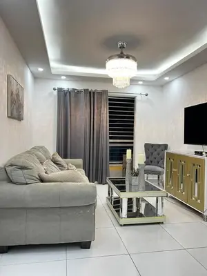 a living room with a couch and a tv at Apartamento O3 Palma Real in Santiago de los Caballeros
