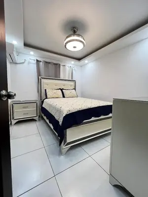 a bedroom with a bed in a white room at Apartamento O3 Palma Real in Santiago de los Caballeros
