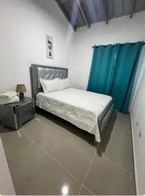 a bedroom with a bed and a blue curtain at Apartamento Media Luna in Cabrera