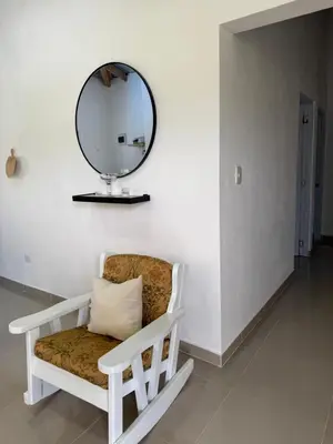 a mirror sitting on a wall next to a chair at Apartamento Media Luna in Cabrera