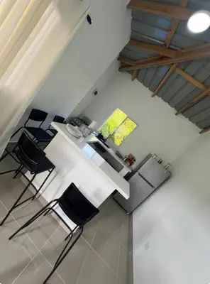an attic room with a white table and chairs at Apartamento Media Luna in Cabrera