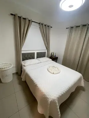 a bedroom with a white bed with a large window at Exclusive Luxury Apartment with Pool in Santiago de los Caballeros