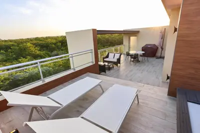 a balcony with white tables and chairs on a building at 404 y 504 Luxurious PH with Jacuzzi near the Beach in La Laguna