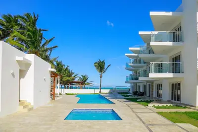 an exterior view of a building with a swimming pool at 0052-Brand new oceanfront condo in Cabarete in Eslabón