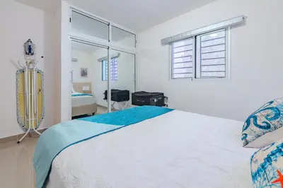 a white bedroom with a bed and a window at Oasis cerca del mar #2 in Monte Adentro