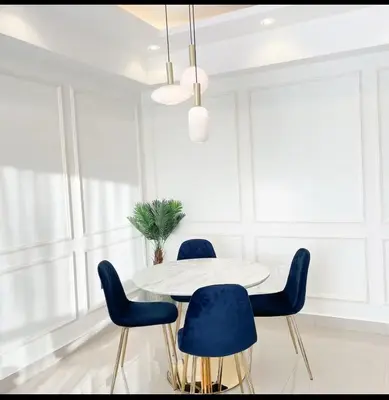 a dining room with a white table and blue chairs at Apartamento boca chica in Andrés