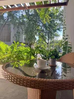 a glass table with a coffee cup on a patio at Perla Marina Beach Condo- Walk to Yoga, Spa & Food in Sosúa