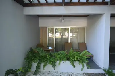 a patio with two chairs and a table with plants at Perla Marina Beach Condo- Walk to Yoga, Spa & Food in Sosúa