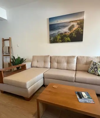 a living room with a couch and a coffee table at Perla Marina Beach Condo- Walk to Yoga, Spa & Food in Sosúa