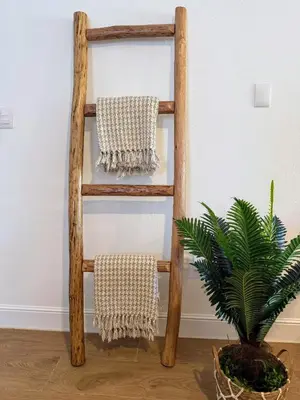 a wooden towel rack with two towels next to a plant at Perla Marina Beach Condo- Walk to Yoga, Spa & Food in Sosúa