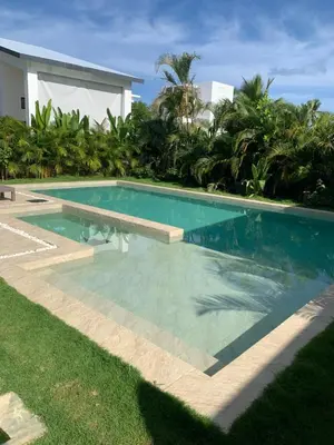 a swimming pool next to a villa at Taina village in Las Terrenas