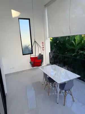 a room with a table and chairs and a swing at Taina village in Las Terrenas