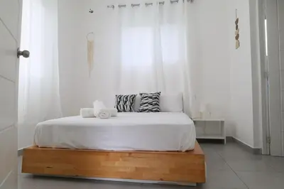 a white bedroom with a bed with two towels on it at Ilaria Bayahibe By Mireya in Bayahibe