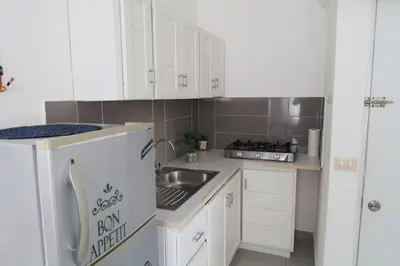 a small kitchen with white cabinets and a sink at Ilaria Bayahibe By Mireya in Bayahibe