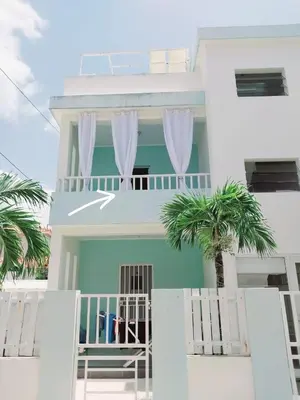 a white house with palm trees in front of it at Ilaria Bayahibe By Mireya in Bayahibe