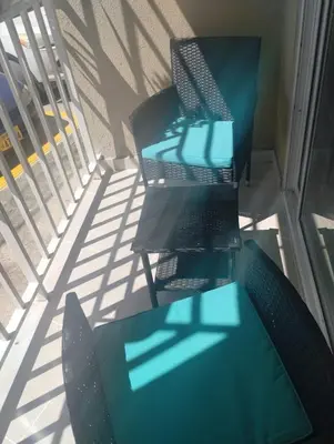 two tables and chairs on a balcony with shadows at Cómodo Apartamento en Santiago in Santiago de los Caballeros