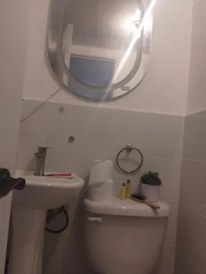 a bathroom with a mirror and a toilet and a sink at Cómodo Apartamento en Santiago in Santiago de los Caballeros